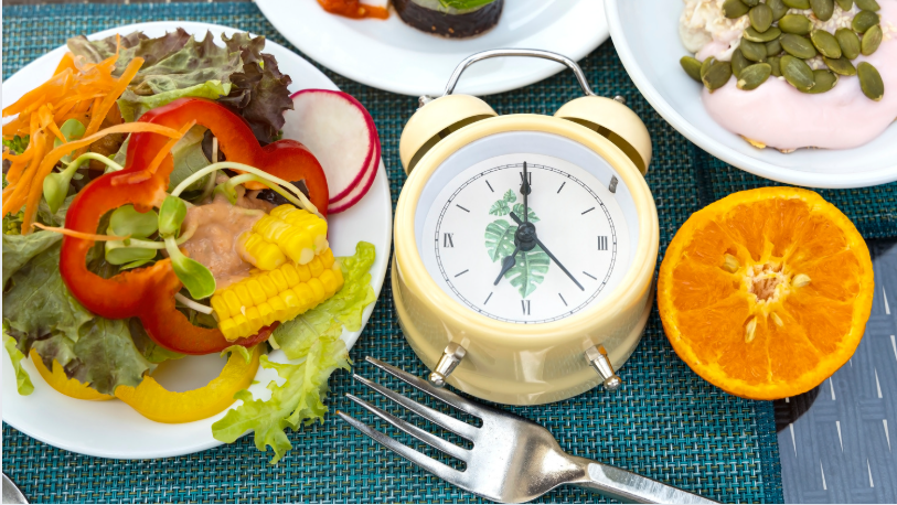 Intermittent fasting concept with healthy food on a table and clock, symbolizing weight loss without starving yourself at home